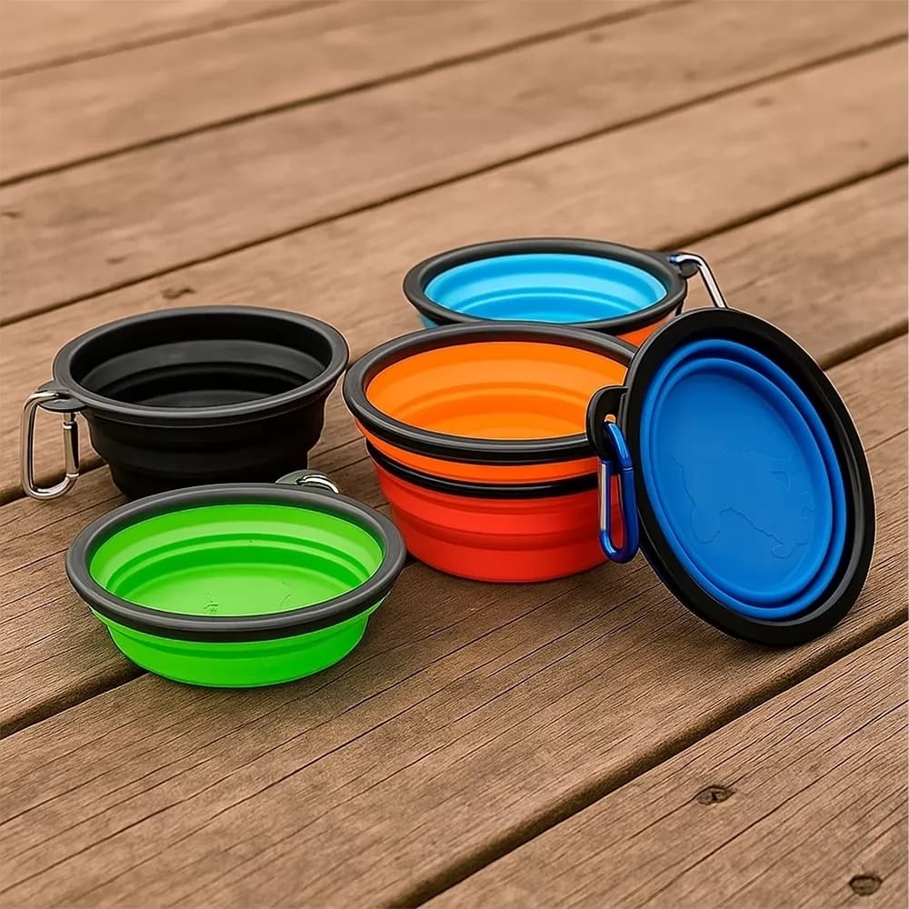 Tigelas retráteis para pet 350ml de silicone em cores variadas com mosquetão sobre madeira